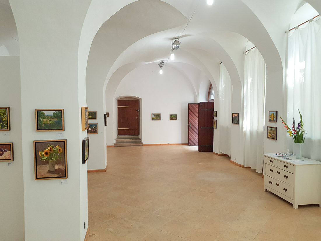 A large bright room with paintings on the wall.